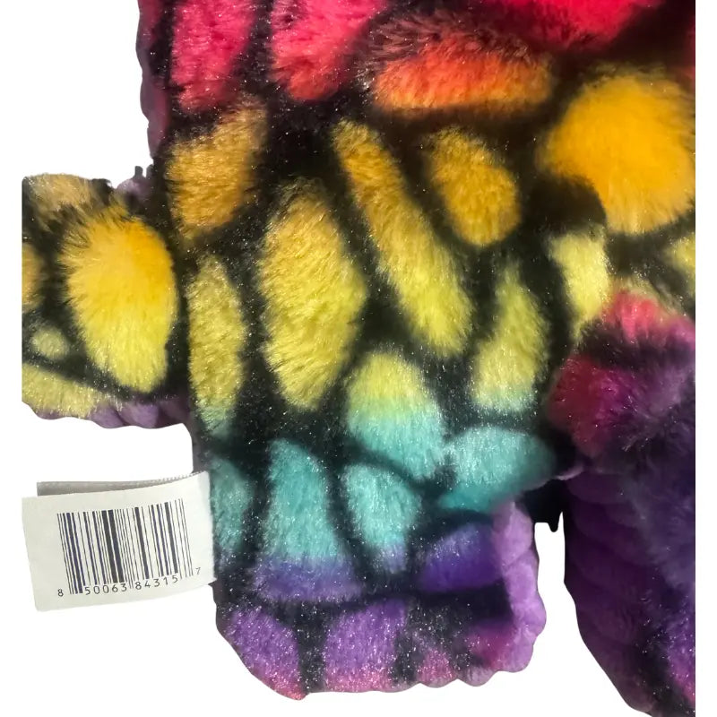 Back view of YooZoo Puzzlez Riley Rainbow Giraffe plush showing tail and fabric tush tag
